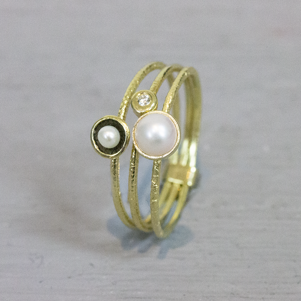 Ring bestaande uit drie losse ringen met parel en diamant. 0.015ct