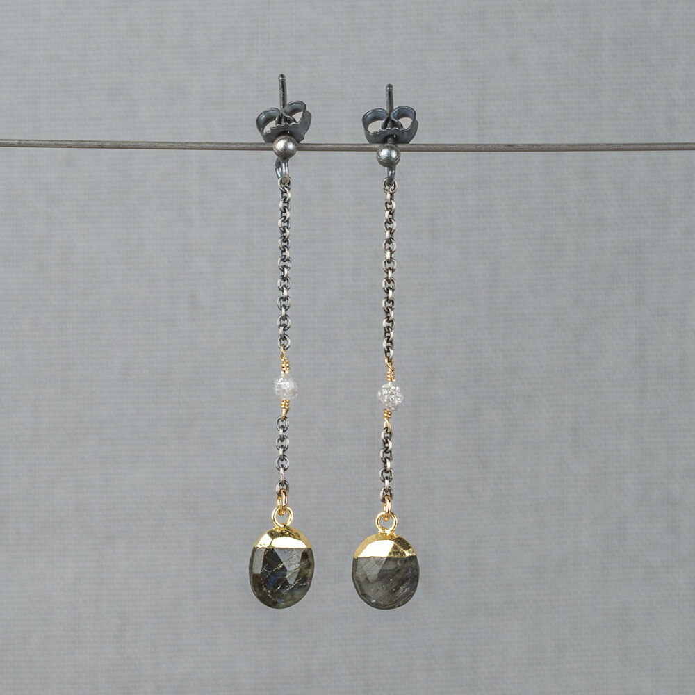 Oorbel gemaakt van 925 geoxideerd sterling zilver in combinatie met zilver verguld en de edelstenen Labradoriet en Ruwe Diamant. Labradoriet is een magische, beschermende en spirituele steen. Wanneer je de steen beweegt/draait, komen de kleuren van de regenboog tevoorschijn. Ruwe Diamant verlicht emotionele en geestelijke pijn, vermindert angst en zorgt voor een nieuw begin. Combineer deze oorbellen met andere sieraden van Jeh Jewels voor een complete look!