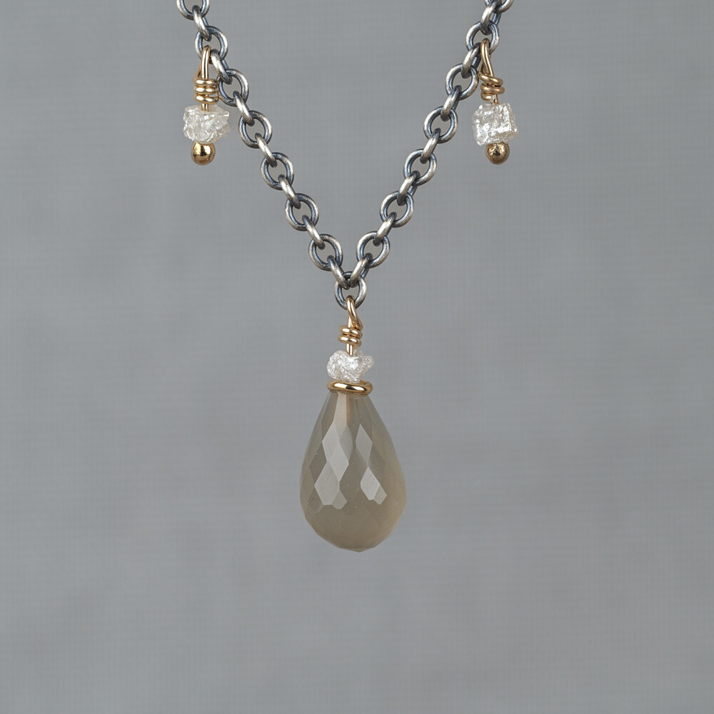 Collier gemaakt van 925 geoxideerd sterling zilver in combinatie met zilver verguld en de edelstenen Grijze Maansteen en Ruwe Diamant. Combineer met een paar oorbellen, een armband en een ring voor een complete look!