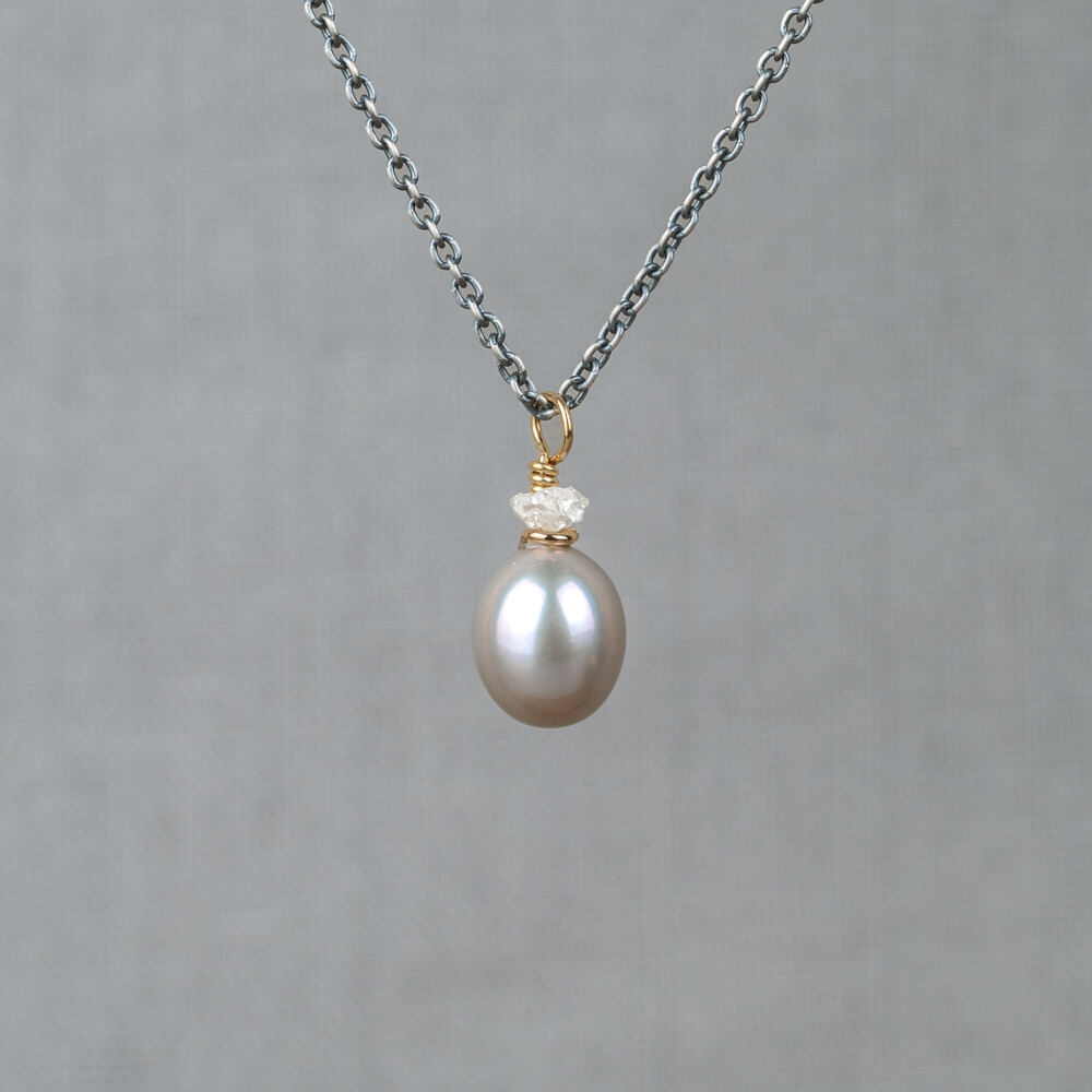 Collier gemaakt van 925 geoxideerd sterling zilver in combinatie met zilver verguld en de edelstenen Grijze Parel en Ruwe Diamant. Lees alles over deze stenen via onderstaande button. Combineer dit collier met de bijpassende oorbellen!