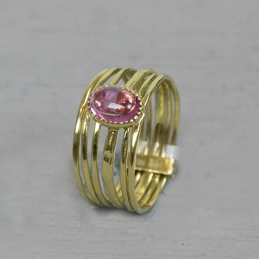 Ring bestaande uit meerde losse bandjes met in het midden een ovale roze tourmalijn edelsteen.