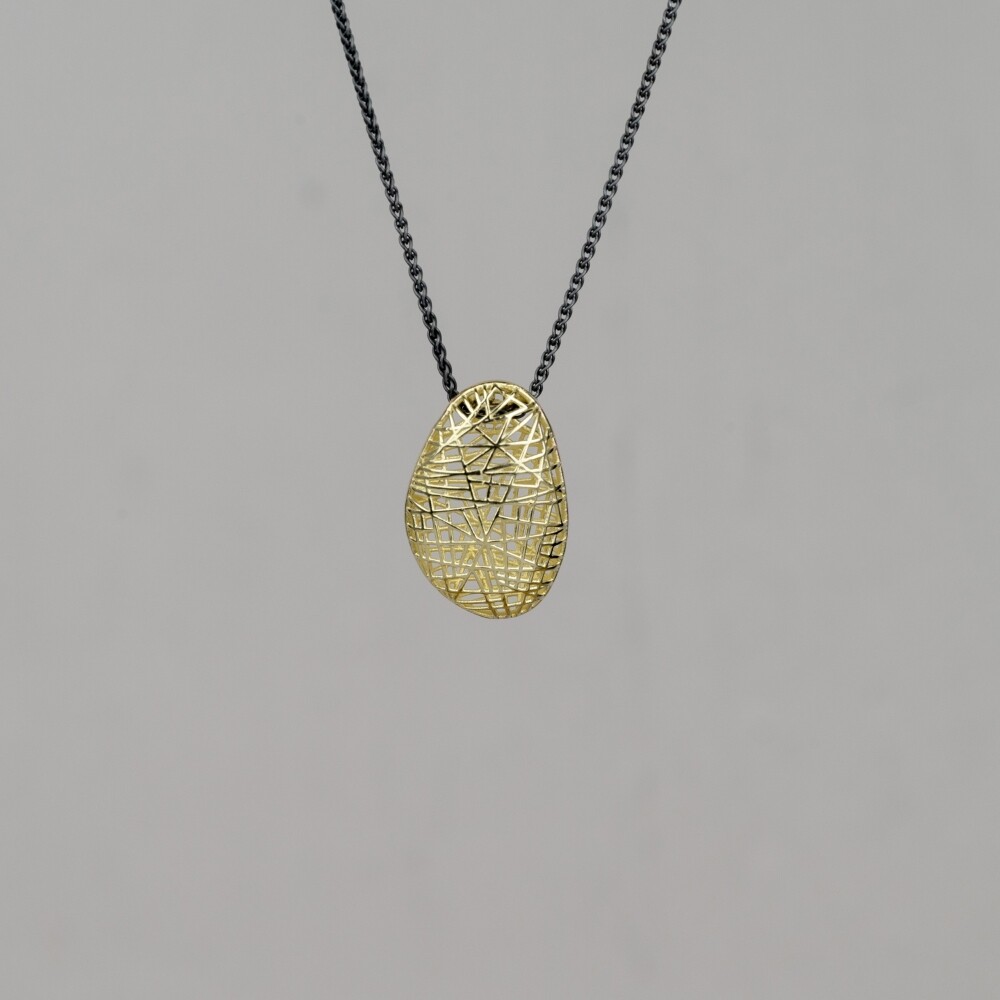 Collier gemaakt van geoxideerd zilver met daaraan een hanger in de vorm van een kei gemaakt van 14 karaat 3D goud.