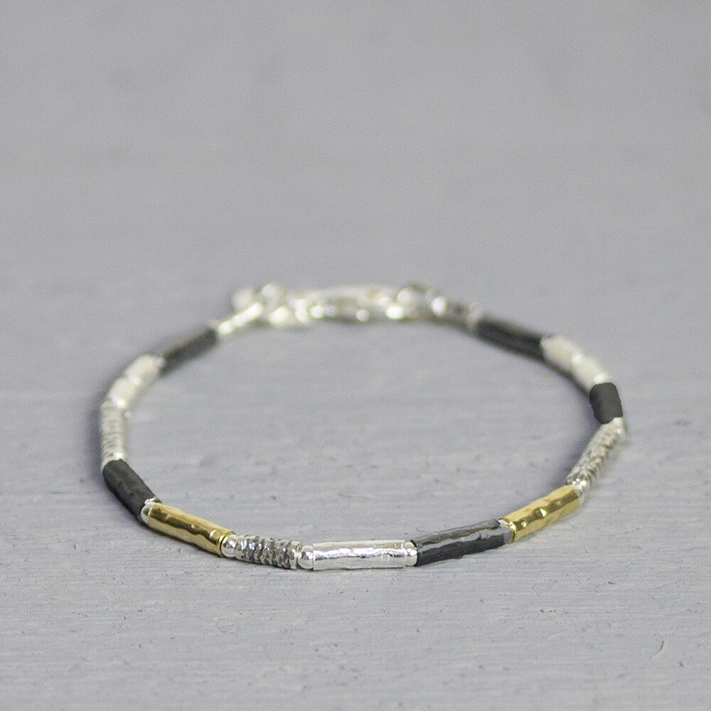 Armband gemaakt van 925 sterling zilver, geoxideerd zilver en goldfilled. Deze armband is een uitbreiding op de 17710, heeft afwisselend de eerder genoemde metaalsoorten en is bewerkt met een lichte hamerslag. Over een aantal schakels zit een zilver bandje, dit creeert een speels effect. Het is bekend dat geoxideerd zilver na verloop van tijd vervaagd. De glans van 925 sterling zilver maakt het een gewild edelmetaal voor de vervaardiging van sieraden. Het bestaat uit 92,5% puur zilver en 7,5% koper. Puur zilver is een zacht en buigzaam materiaal, het koper in 925 sterling zilver zorgt voor de stevigheid. De sieraden van Jeh Jewels zijn nikkel vrij. Gold filled komt uit Amerika en wordt daar al langer gebruikt voor de vervaardiging van sieraden met een "touch of gold" voor een betaalbare prijs. Het gold filled blijft op kleur, is slijtvast en de goudlaag is dik genoeg om lang te kunnen genieten van de warme uitstraling van goud. Gold filled wordt veelal ook goed verdragen door mensen die allergisch zijn voor andere metalen dan goud.