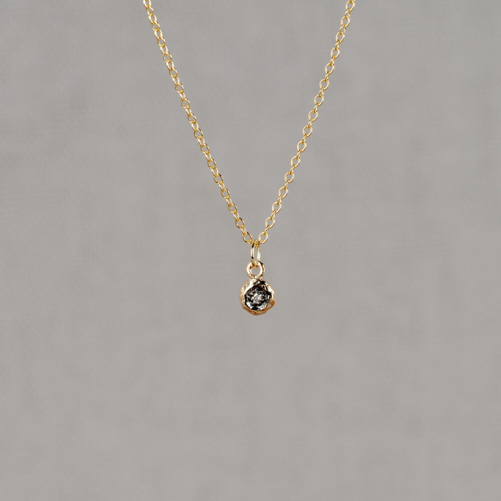Dit prachtige collier is gemaakt van 14 karaat goud en heeft een hanger met zwarte rhodium en een diamant van 0,01 karaat. De combinatie van materialen zorgt voor een elegante uitstraling. Draag dit collier als een statement piece bij zowel casual als formele outfits. De subtiele glans van de diamant zal zeker de aandacht trekken. Een must-have voor elke sieradencollectie.