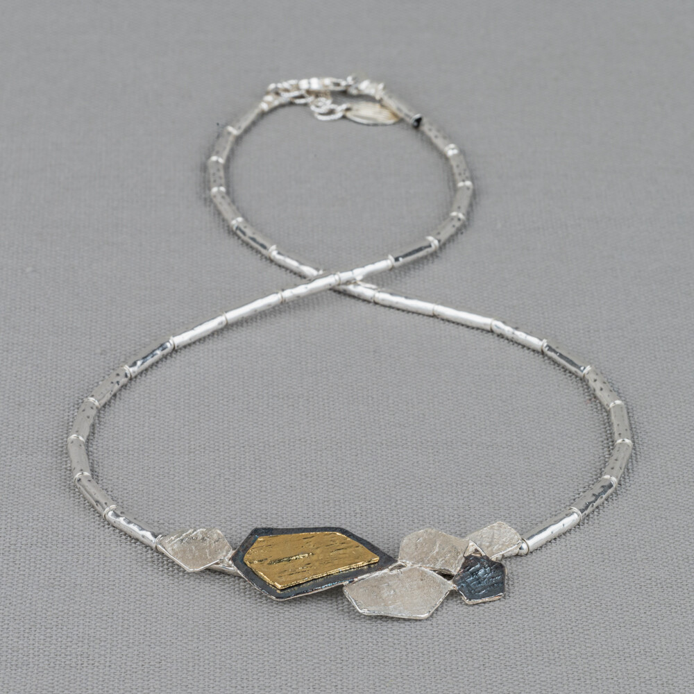 Collier gemaakt van 925 sterling zilveren buisjes in combinatie met een hanger van geoxideerd zilver en verguld. Combineer dit mooie collier met een paar oorsieraden, een armband en ring voor een complete look!