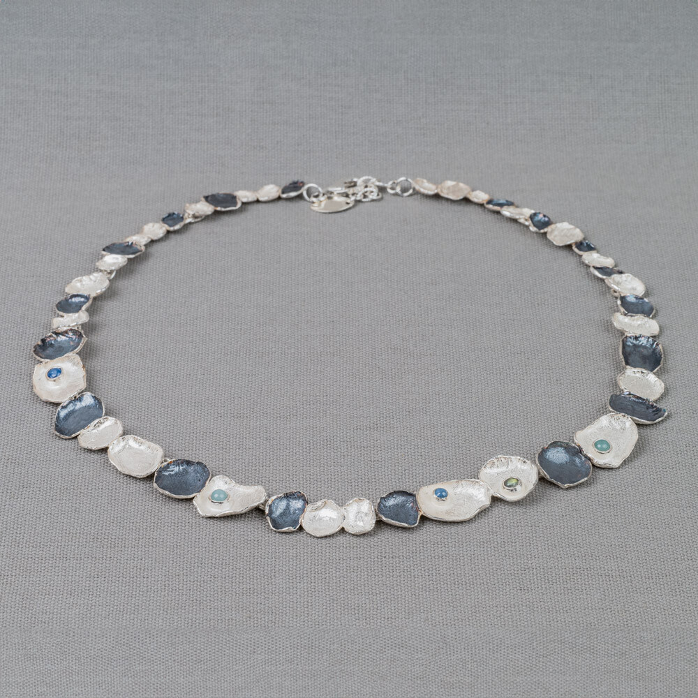 Collier gemaakt van 925 sterling zilver en geoxideerd zilver. In deze ketting vind je ook de edelstenen Aquamarijn, Kyaniet en Labradoriet terug. Lees alles over deze verschillende edelstenen via onderstaande button!
