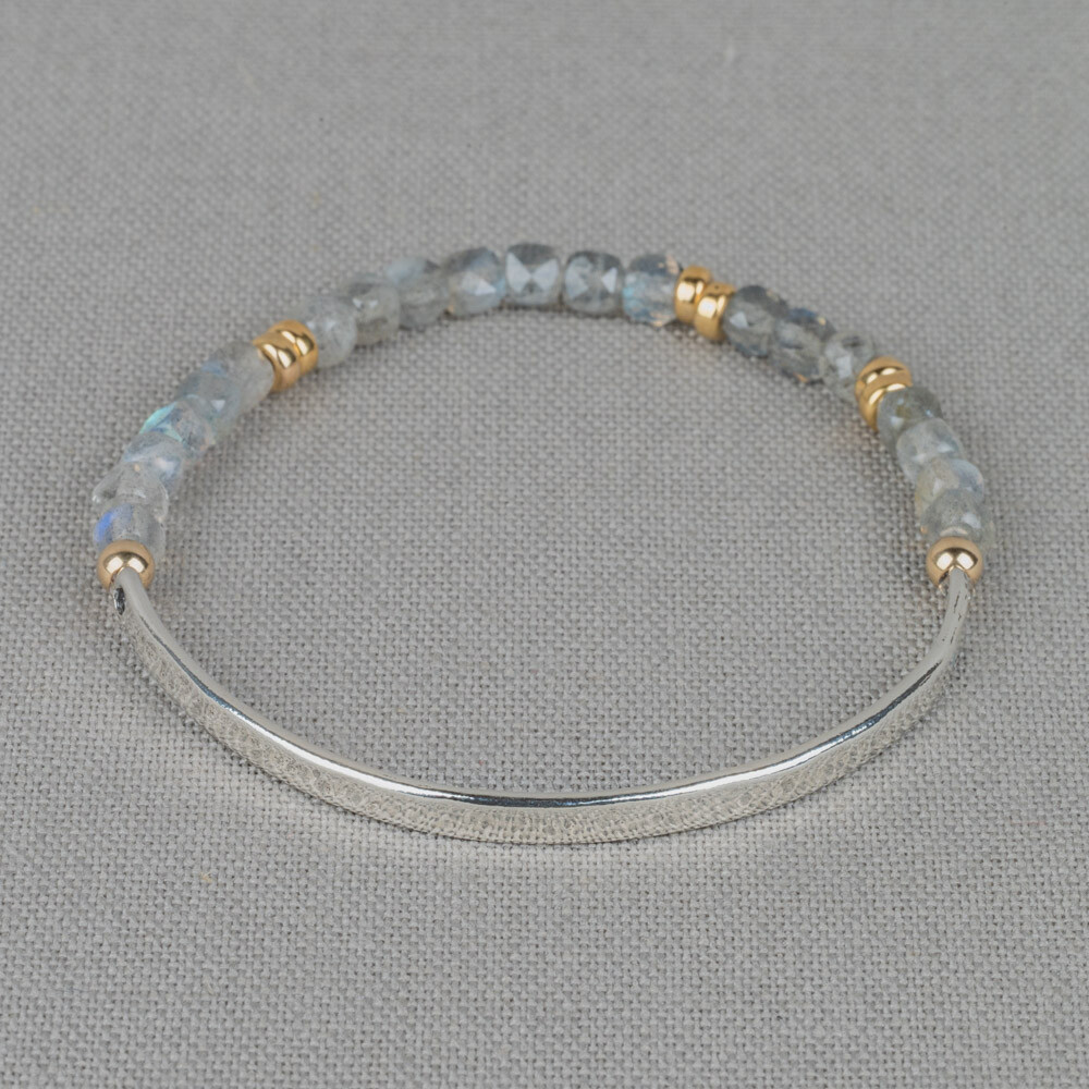 Armband gemaakt van 925 sterling zilver in combinatie met Goldfilled balletjes en de edelsteen Labradoriet. Deze armband is voor de helft gemaakt van een zilveren bangle armband en de andere helft zijn edelstenen. Door middel van het elastiek wat gebruikt is, kun je de armband gemakkelijk om en af doen. Combineer met onze andere sieraden!