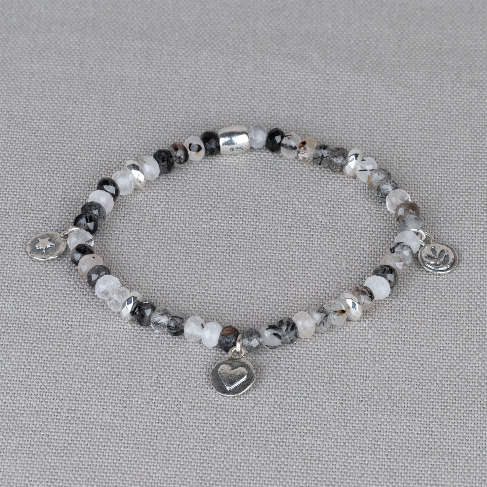 Armband gemaakt van de edelsteen Black Rutiel in combinatie met 925 sterling zilveren bedels. Het armbandje is gemaakt van elastiek waardoor je hem makkelijk om kunt doen. Combineer met een mooi collier, oorbellen en een ring voor een complete look!