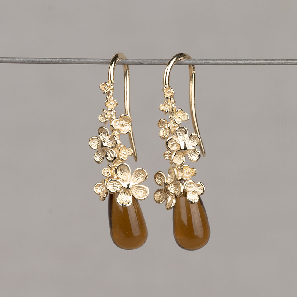 Oorhanger gemaakt van 14 karaat goud in combinatie met de edelsteen Cognac Kwarts. Deze oorhanger kan perfect gecombineerd worden met de andere sieraden uit de Blossom-lijn.
