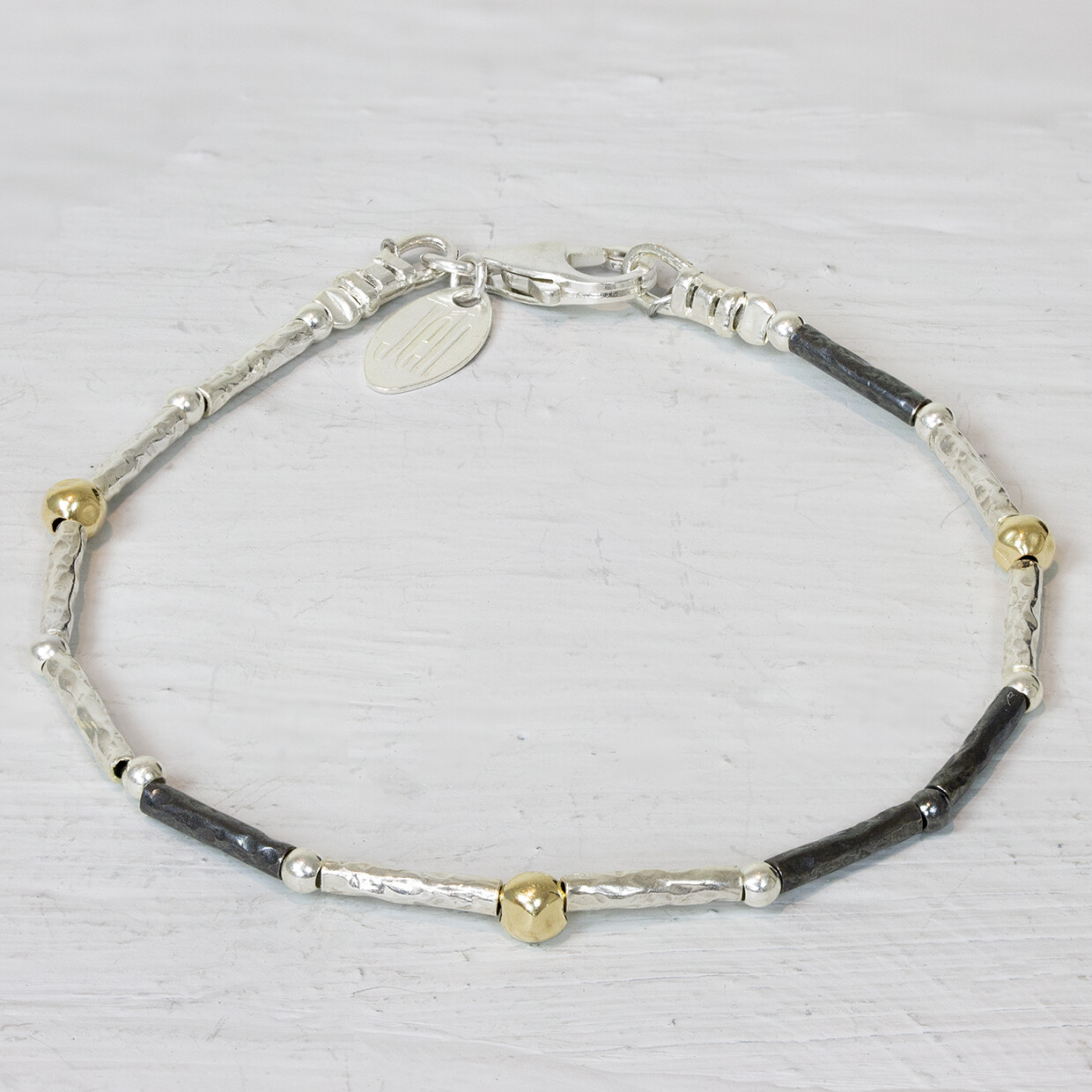 Armband van de najaarscollectie 2022 van Jeh Jewels gemaakt met buisjes van zilver en geoxideerd zilver met daartussen goldfilled balletjes. Ideaal om te matchen met het bijpassende collier. De glans van 925 sterling zilver maakt het een gewild edelmetaal voor de vervaardiging van sieraden. Het bestaat uit 92,5% puur zilver en 7,5% koper. Puur zilver is een zacht en buigzaam materiaal, het koper in 925 sterling zilver zorgt voor de stevigheid. De sieraden van Jéh Jewels zijn nikkel vrij. Op dit sieraad is gebruik gemaakt van geoxideerd zilver, dit is een oppervlakte bewerking. Het is mogelijk dat de geoxideerde laag na verloop van tijd door slijtage gaat vervagen. Goldfilled komt uit Amerika en wordt daar al langer gebruikt voor de vervaardiging van sieraden met een "touch of gold" voor een betaalbare prijs. Het goldfilled blijft op kleur, is slijtvast en de goudlaag is dik genoeg om lang te kunnen genieten van de warme uitstraling van goud. Goldfilled wordt veelal ook goed verdragen door mensen die allergisch zijn voor andere metalen dan goud.