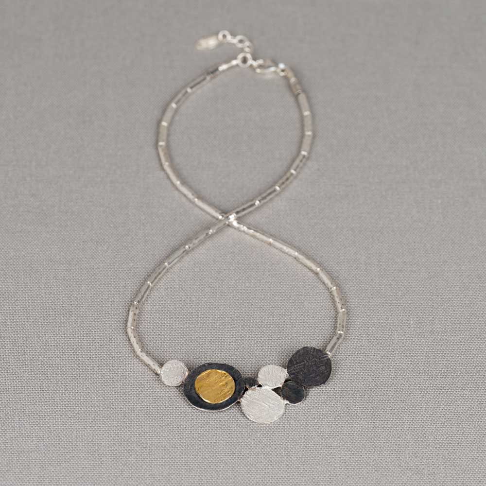 Collier gemaakt van 925 sterling zilveren buisjes in combinatie met een hanger van geoxideerd zilver en verguld. Combineer dit mooie collier met een paar oorsieraden, een armband en ring voor een complete look!