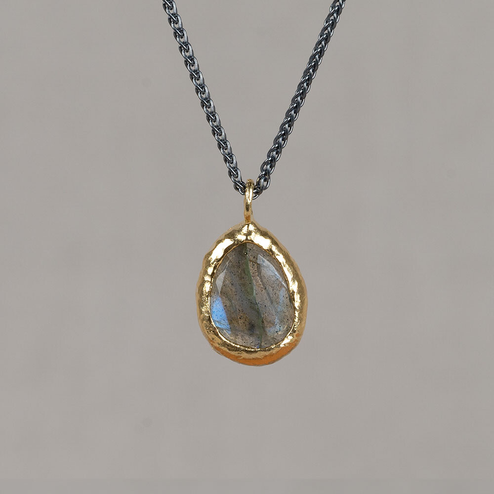 Collier gemaakt van 925 geoxideerd sterling zilver met daaraan een vergulde hanger met de edelsteen Labradoriet. Combineer met de bijpassende oorbellen voor een complete look!
