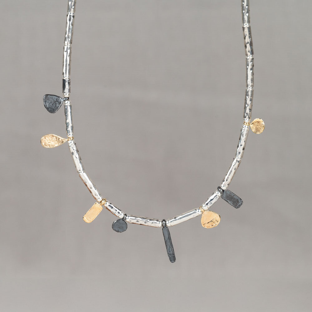 Collier gemaakt van 925 sterling zilveren buisjes met daaraan deeltjes gemaakt van geoxideerd zilver en verguld. Combineer met een paar mooie oorbellen, een armband en ring voor een complete look!