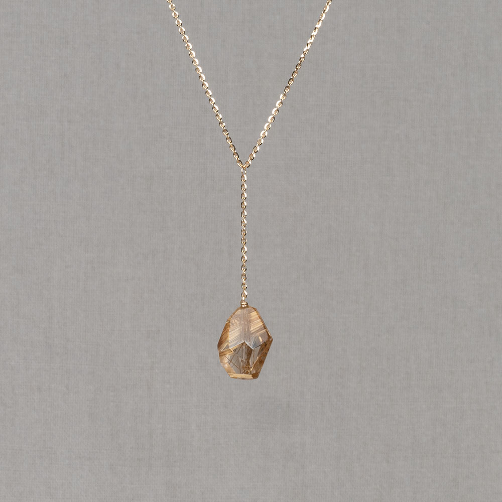 Collier gemaakt van 14 karaat goud in combinatie met een hanger met Gold Rutiel. Aan deze steen zit ook nog een stukje ketting (2 cm). Draag dit collier met mooie oorbellen, een ring en armband voor een complete look!