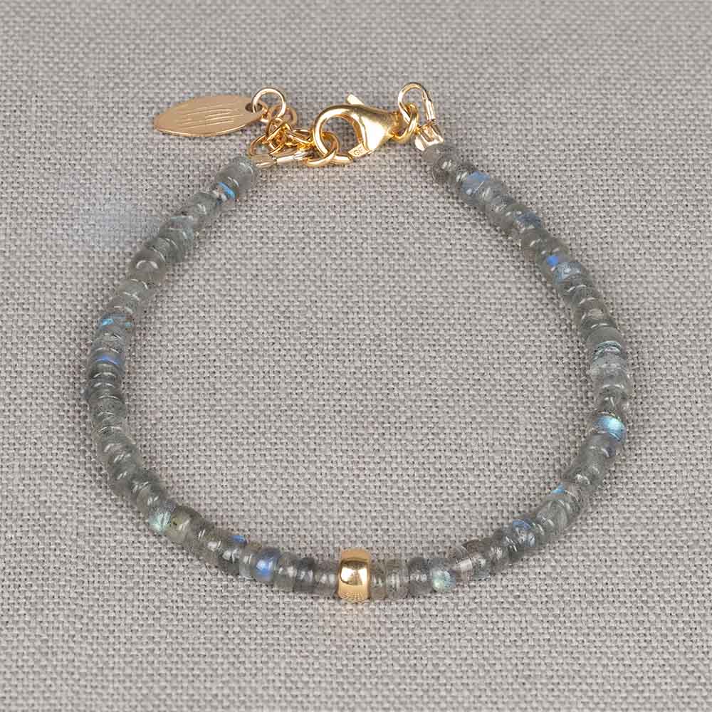 Armband gemaakt van de edelsteen Labradoriet met in het midden een Goldfilled bolletje. Labradoriet is een magische, beschermende en spirituele steen. Wanneer je de steen beweegt/draait, komen de kleuren van de regenboog tevoorschijn. Lees alles over de werking van deze edelsteen via onderstaande button. Combineer deze armband met een mooi collier, een ring en oorbellen voor een complete look!