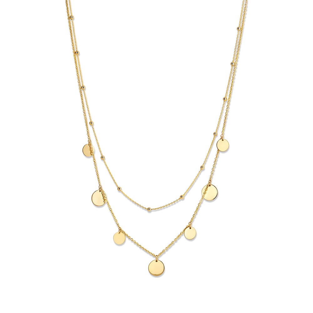 Collier met dubbele geelgouden ketting met bolletjes en hangende coins. Zo onstaat een modern layering effect.
