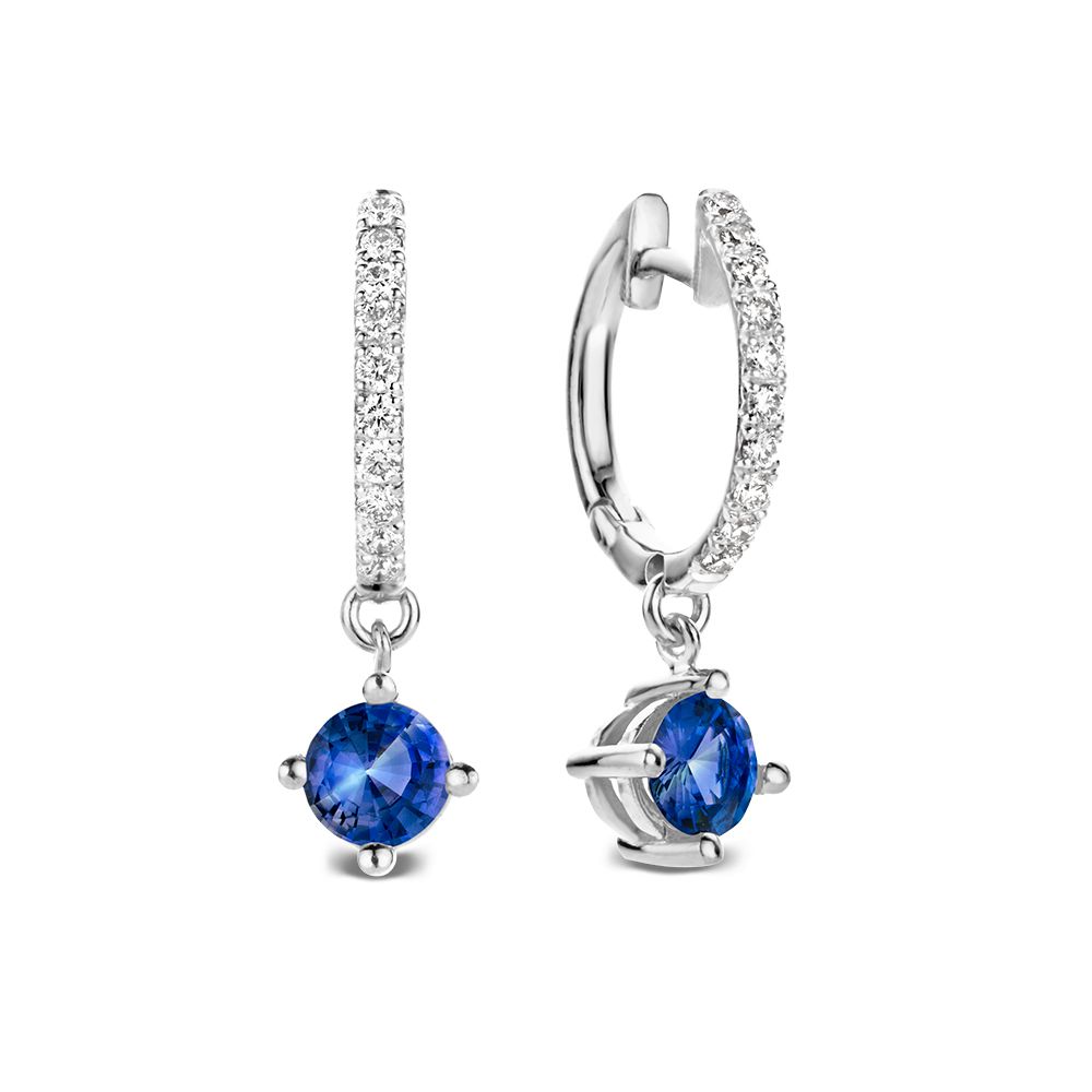 Witgouden oorringen met fonkelende diamanten en blauwe saffieren als luxe aanhangers met een speels effect.
