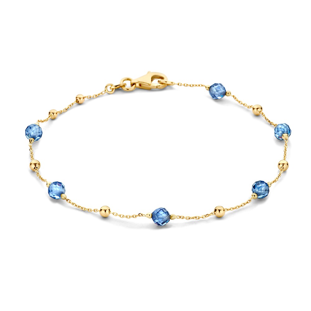 Geelgouden armband met donkerblauwe zirkonia bolletjes.
