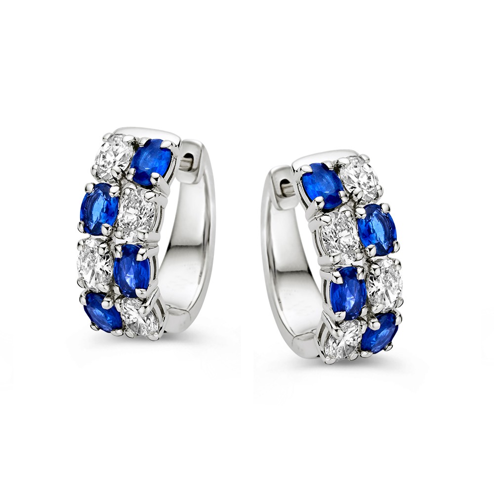 Witgouden oorringen met ovaal geslepen blauwe saffieren en diamanten.
