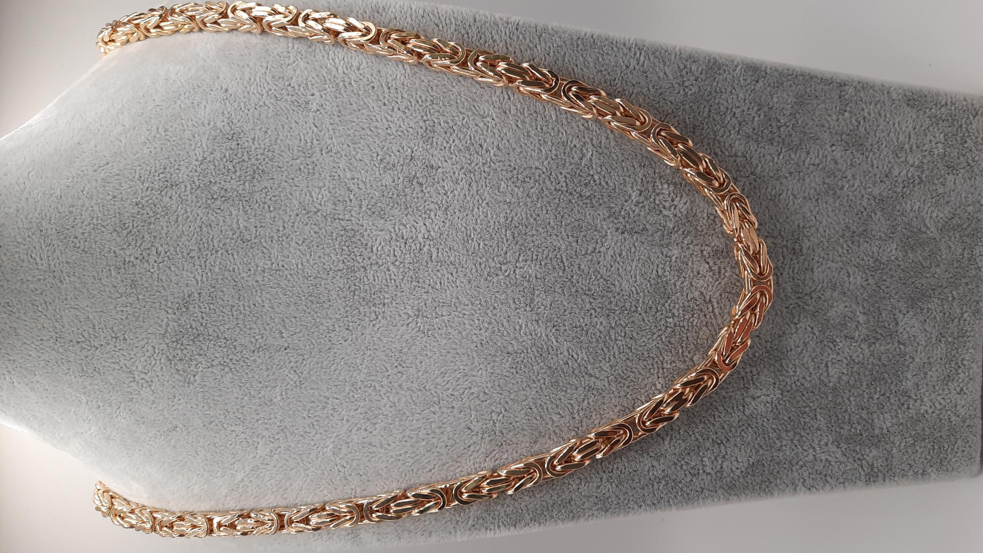 De koningsketting met modelnummer 000140 is een gouden ketting van 14 karaat, met een gewicht van 64,82 gram en een breedte van 5,7 mm. De ketting is goudkleurig en valt binnen de categorie sieraden. Met een lengte van 65 cm is deze luxe ketting ideaal om te dragen bij feestelijke en formele gelegenheden.