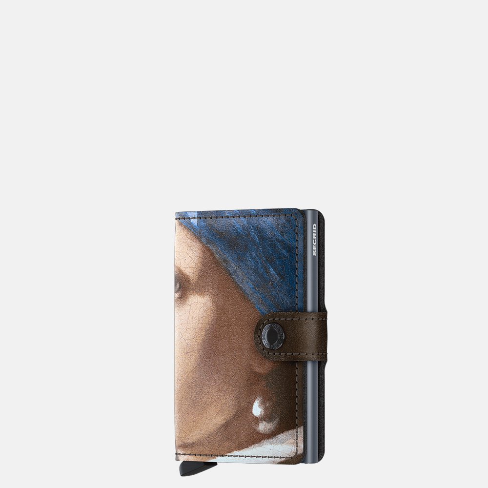 De Miniwallet van het bekende merk Secrid is een unieke accessoire die zowel als portemonnee als stijlvolle kaarthouder fungeert. Deze wallet is voorzien van een opdruk van het bekende schilderij van het meisje met de parel van Johannes Vermeer. Draag het in je tas voor gemakkelijke toegang tot kaarten en contant geld. Ideaal voor dagelijks gebruik en speciale gelegenheden. Voeg een vleugje elegantie toe aan je outfit met deze veelzijdige miniwallet.