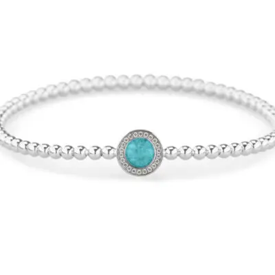 Cirkel bolletjes armband. Deze armband is voorzien van een staaldraad (geen elastiek). De armband moet net over de hand kunnen schuiven om mooi aangesloten aan de pols te kunnen dragen. Dit sieraad wordt zichtbaar aan de voorkant gevuld met as of haar en wordt vermengd met onze speciale hars.