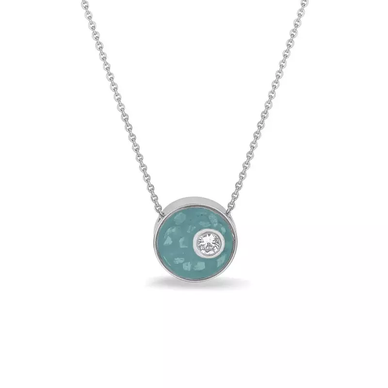 Rond hangertje met zirkonia, inclusief collier. Dit hangertje kan aan de voorkant gevuld worden met as, moedermelk of haar. Op de achterkant is eventueel nog de mogelijkheid voor een gravure. Denk bijvoorbeeld aan een naam, initialen of een vingerafdruk.