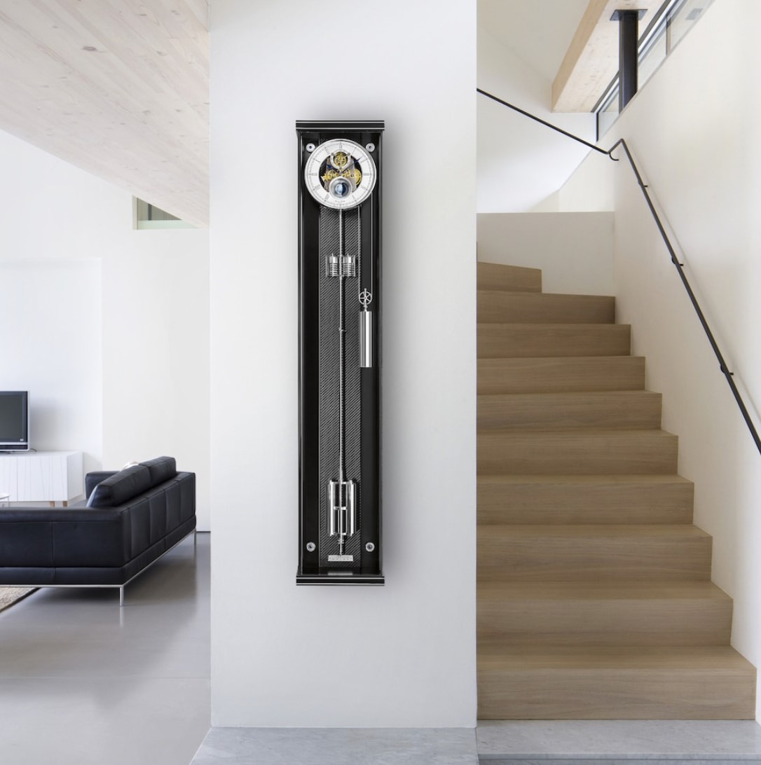 Opus Secunda M 130 met Precision seconde slinger.
Het anti-reflecterende mineraalglas biedt een volledig onbelemmerde blik op de wijzerplaat, wijzers, het uurwerk en de slinger. De U-vormige beglazing wordt door vakmensen in verstek geslepen en gelijmd. De randen en de voet zijn versierd met metalen inlegwerk. En dankzij de discrete magnetische sluiting op de deur is er geen vergrendelingshaak nodig.
Het elegante ontwerp van de Opus Secunda M 130 wordt gedomineerd door een skeletachtige wijzerplaat, die een glimp van de vergulde tandwielen toelaat. De bolvormige maan in een trechter geeft het uurwerk ook een unieke look. De kogelmaan is met de hand beschilderd in de productie met de hoogste mate van aandacht voor detail.

Deze precisie seconde slingerklok is een uiterst nauwkeurig uurwerk, met een maximale nauwkeurigheidsafwijking van drie tot vier seconden per maand. Een gewicht dat langs de zijkant loopt, zorgt voor een gangreserve van 30 dagen. De fijne tandwielvertanding en het gebruik van kogel- en/of Robijnlagers voor alle draaiende onderdelen zorgen voor een levensduur die vele generaties meegaat. De lichte temperatuur geïnduceerde veranderingen in de lengte van de Super Invar slingerstang worden gecompenseerd door een nauwkeurig berekende compensatiebuis. Om grotere nauwkeurigheidsafwijkingen door schommelingen in de luchtdruk te voorkomen, is een dubbele aneroïde systeem aan de slinger toegevoegd.
De minimalistische en moderne elegantie worden gecombineerd in met onweerstaanbaar mooi precisie-uurwerk.