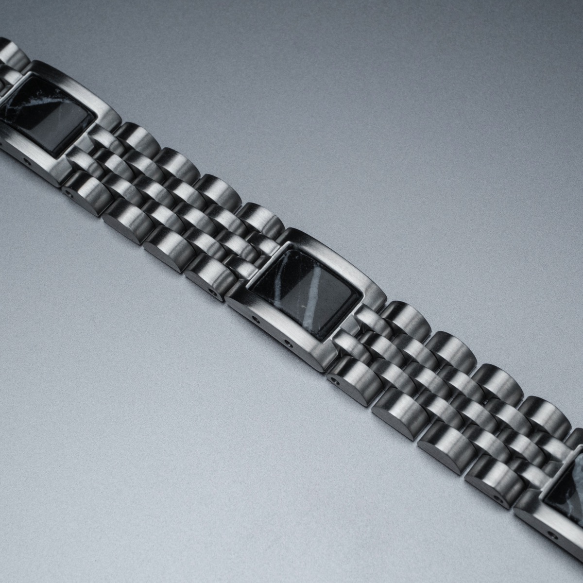 Elegantie ontmoet natuur. De Pentachord Bandlets zijn geïnspireerd op de harmonie van een vijftonig akkoord en combineren fijn marmer en hoogwaardig roestvrij staal om een ​​unieke armband te creëren. Ontdek uitzonderlijk comfort en ongeëvenaarde elegantie dankzij ons innovatieve, vijf-link ontwerp!