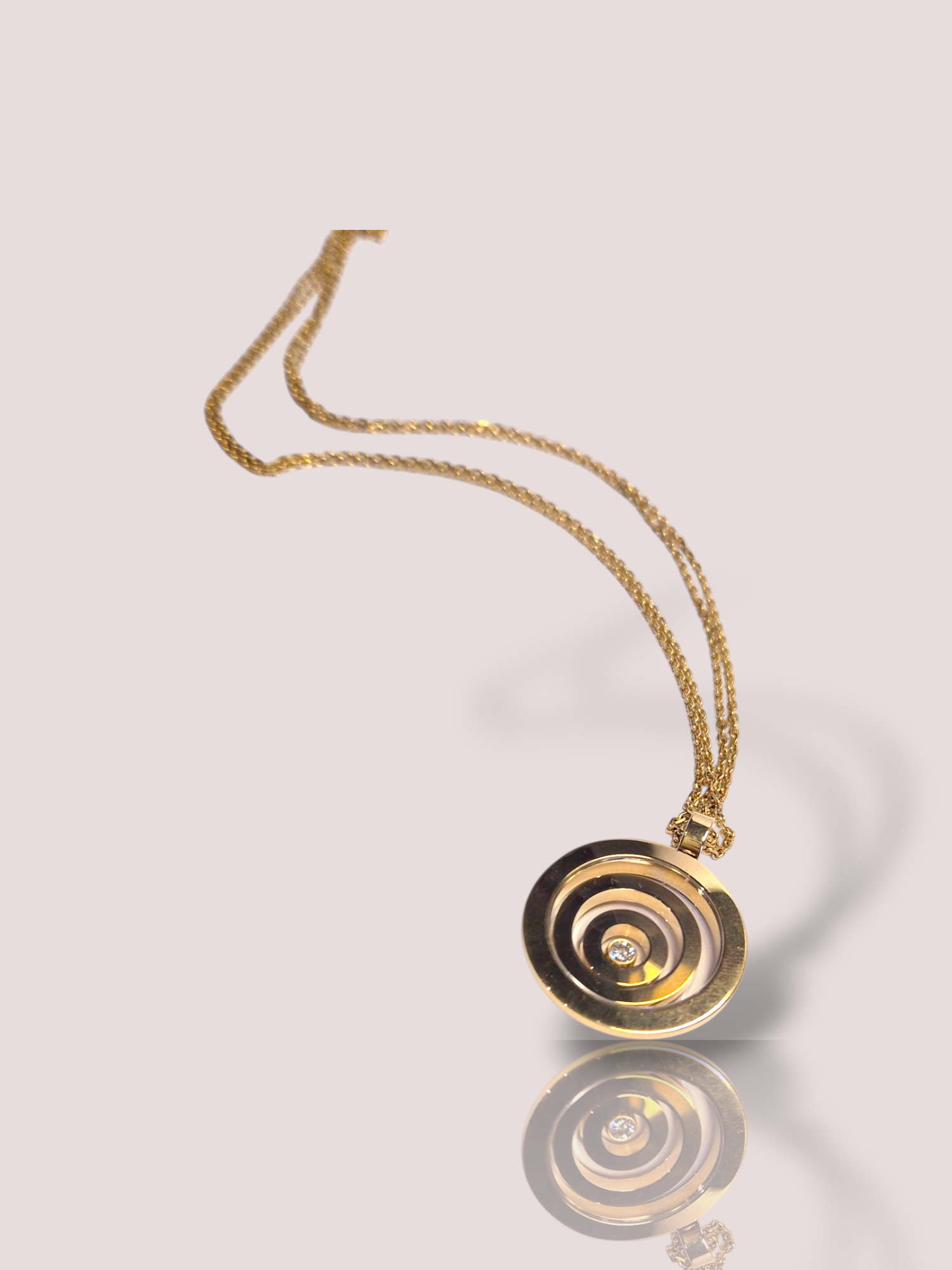 Dit vintage Chopard 18k geelgouden Happy Spirit collier is een verfijnd sieraad met een dubbel dun kettinkje en de prachtige iconische Happy Spirit hanger. De hanger bestaat uit een zware gouden cirkel met daarin 2 bewegende gouden cirkels en een bewegende diamant, zoals u van Chopard gewend bent. 

Dit juweel is ideaal voor zowel formele als casual gelegenheden en voegt een vleugje elegantie toe aan elke outfit. Draag het op een eenvoudige blouse of elegante avondjurk voor een tijdloze look. De diameter van de hanger is 3,5 cm en de lengte van het collier is 60 cm.