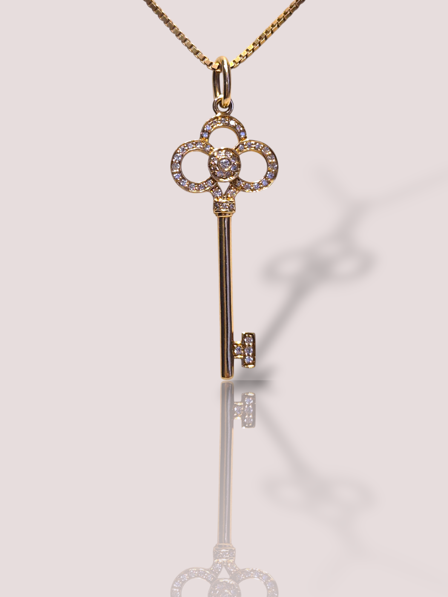 Dit prachtige vintage Tiffany & Co 18k gouden collier heeft de iconische sleutel hanger van 3,5 bij 1,5 cm bezet met een sprankelende diamanten. De gouden ketting is merkloos, de hanger is origineel Tiffany. Het collier straalt elegantie en stijl uit en kan zowel casual als chic gedragen worden. De beste manier om het te dragen is met een simpel wit T-shirt voor een minimalistische look of met een cocktailjurk voor een glamoureuze uitstraling. Voeg dit exclusieve stuk toe aan je collectie voor een tijdloze en luxueuze touch.
