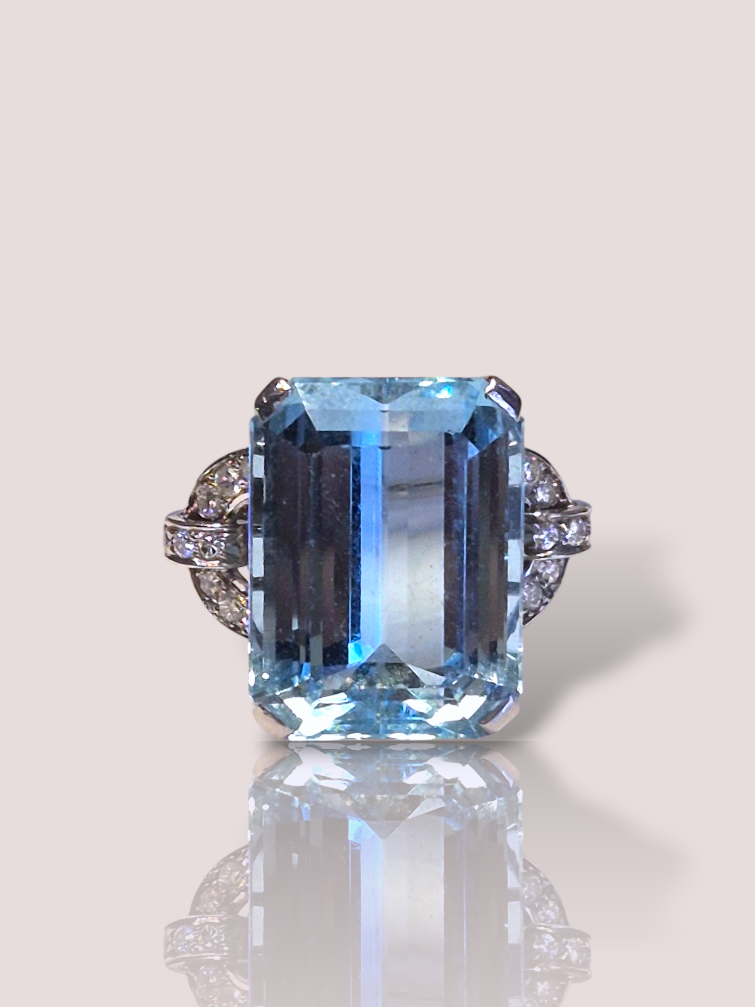 Deze vintage Art-Deco platina statement ring bevat een schitterende Santa Maria aquamarijn, omringd door glanzende diamanten. De aquamarijn is prachtig zuiver en heeft een gewicht van 21ct. De aquamarijn wordt omgeven door 18 briljant geslepen diamanten. Draag deze opvallende ring als middelpunt van je outfit, ideaal voor speciale gelegenheden of om een chique, elegante look te creëren.