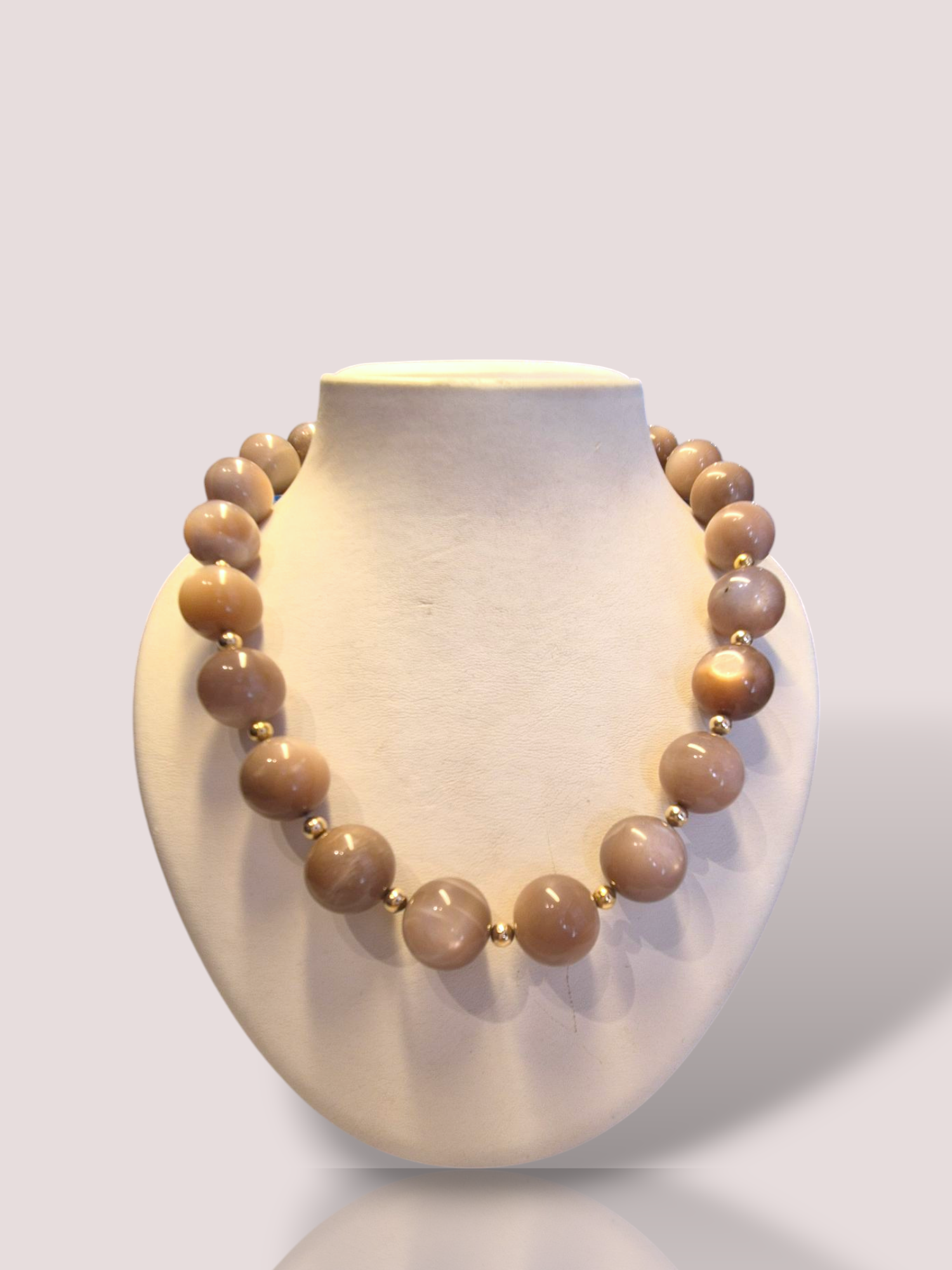 Dit vintage maansteen collier bevat 52 prachtige taupekleurige maansteen kralen met hiertussen subtiele 14k goudbolletjes geplaatst, die een vleugje elegantie toevoegen. Perfect voor zowel dagelijks gebruik als speciale gelegenheden. Combineer het met een eenvoudige outfit om het collier echt te laten stralen. Een must-have voor elke sieradenliefhebber!

De maansteen kralen hebben een diameter van 1,8 cm.
