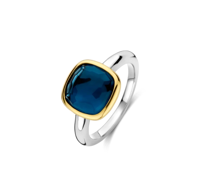 Deze TI SENTO ring 12351DB brengt de serene schoonheid van zomernachten tot uiting. Het betoverende middelpunt—een doorschijnende donkerblauwe cushion-geslepen steen—is met de hand gezet in een vergulde zetting, wat verfijning en diepte uitstraalt. De schacht is verzilverd en afgewerkt met platina voor extra glans en bescherming, waardoor de ring stralend en duurzaam blijft. Deze ring, een belichaming van tijdloze elegantie, verheft moeiteloos elke look, dag en nacht. Draag de ring solo voor een gedurfd, dromerig statement of combineer met andere TI SENTO sieraden voor een gepersonaliseerde, stralende stijl. Van casual zomerse uitstapjes tot elegante avondgelegenheden, de ring voegt een vleugje verfijnde glamour toe aan elk moment. Z