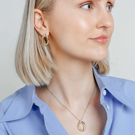 Deze TI SENTO oorbellen 78013ZY combineren eigentijdse flair met moeiteloze elegantie. Gemaakt van 925 sterling zilver, hebben ze een vergulde ovale schakel die hangt aan een pavé gezette cubic zirconia connector. De mix van warme gouden tinten en koele platinakleurige accenten zorgt voor een opvallend contrast. Deze in elkaar grijpende ovalen symboliseren de harmonie tussen gedurfde uitstraling en schoonheid. Nikkelvrij en hypoallergeen voor luxueus comfort.