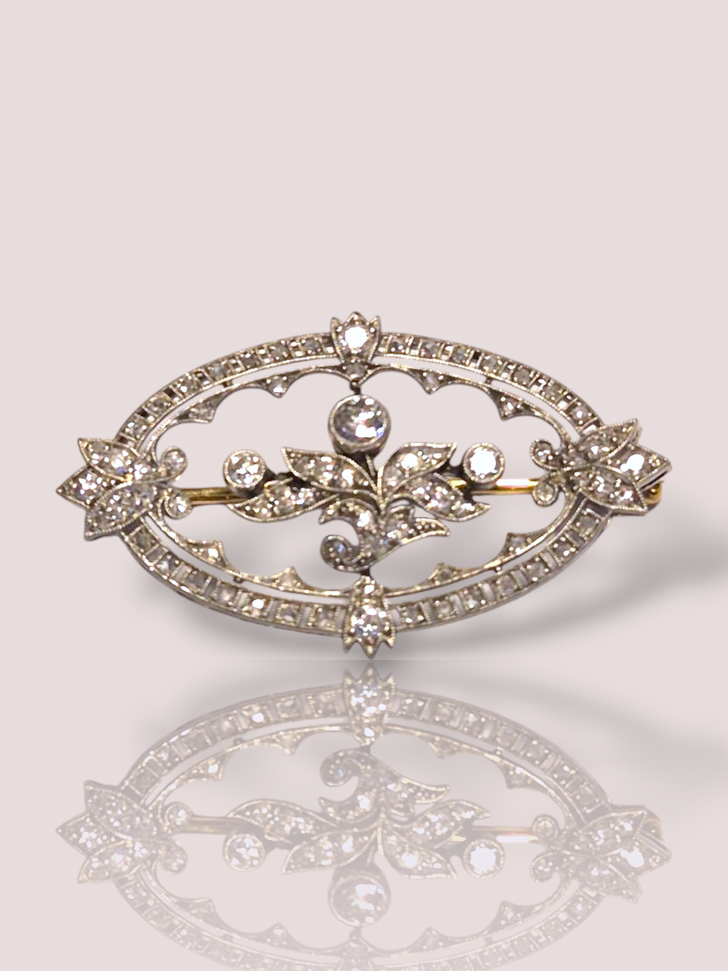 Deze Belle Époque broche combineert wit en geel goud met fonkelende diamanten. Het is een verfijnd sieraad dat elegantie uitstraalt. Draag deze broche op een blazer, avondjurk of sjaal voor een klassieke en stijlvolle look die elke outfit een luxe accent geeft. Een tijdloos accessoire voor speciale gelegenheden.

De broche is 6 bij 3 cm en bevat 77 diamanten in roosvorm en oud slijpsel geslepen. 