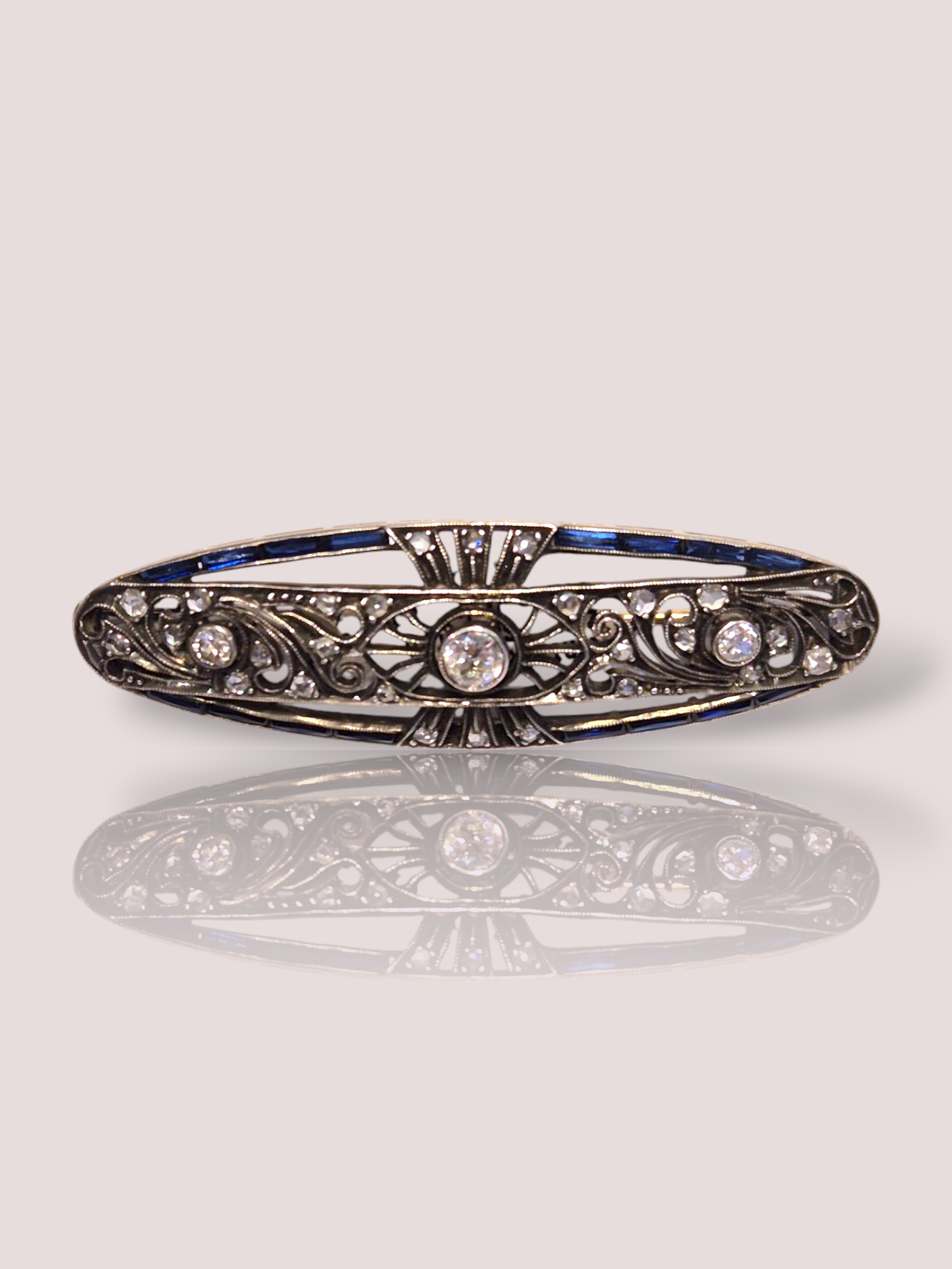 Deze vintage broche is voorzien van Bolsjewiek geslepen diamanten en saffieren, waardoor hij een oogverblindend en luxueus uiterlijk heeft. De diamanten en saffieren zijn gezet in zilver. De broche kan op verschillende manieren gedragen worden, zoals op een blouse, jasje of zelfs op een avondjurk voor een extra vleugje glamour. Voeg deze prachtige broche toe aan je collectie voor een vleugje vintage chic.

De broche is 5 bij 1,5 cm.