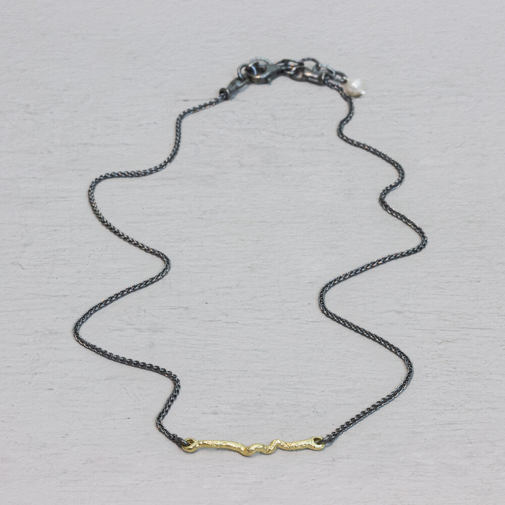 Collier van Jeh Jewels met touch of gold krul. Dit geoxideerd zilveren collier is fijn en subtiel. De gouden krul is verguld. Samen met het geoxiddeerde zilver is dit de perfecte combinatie. Nog een fijn aspect van dit coller, het slotje kan niet naar beneden zakken.