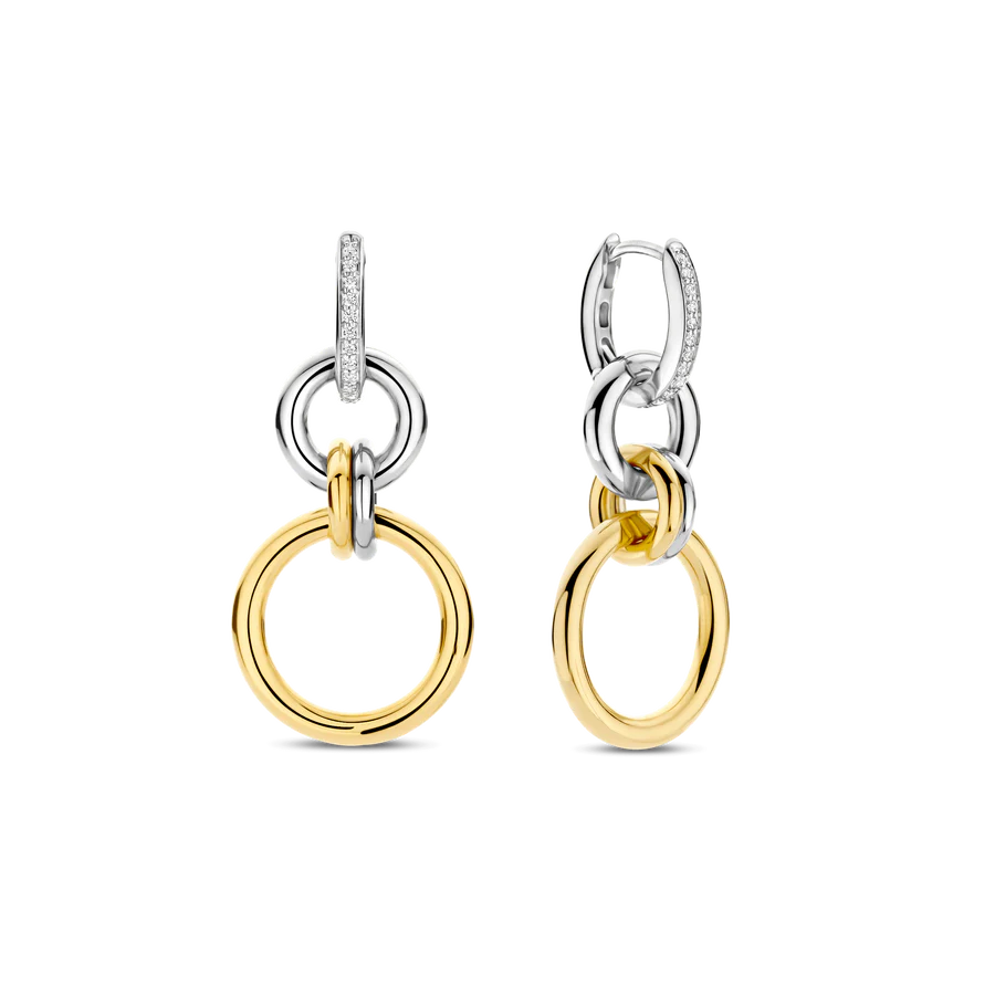 Deze TI SENTO oorbellen 78018ZY zijn een gedurfde interpretatie van moderne elegantie, waarbij strakke geometrie wordt gecombineerd met tijdloze verfijning. Gemaakt van hoogwaardig 925 sterling zilver, hebben deze oorbellen een reeks van in elkaar grijpende cirkels, waarbij gepolijste goudkleurige schakels worden gecombineerd met glanzende zilverkleurige elementen. Een pavégezette cubic zirconia hoepel verankert het ontwerp en voegt een verfijnde schittering toe die het licht vangt bij elke beweging. Het dynamische samenspel van texturen en tinten maakt deze oorbellen veelzijdig. Nikkelvrij en hypoallergeen, zorgen ze voor luxueus comfort bij elk draagmoment. Laat deze in elkaar grijpende hoepels jouw statement zijn van kracht, vloeiendheid en eindeloze stijlmogelijkheden.