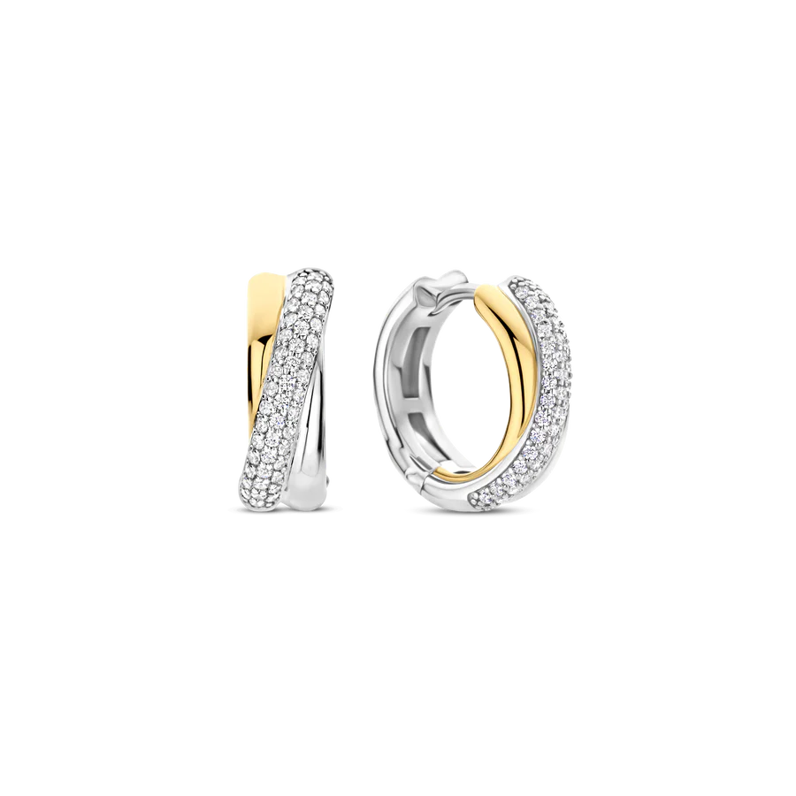 Deze TI SENTO oorbellen 78012ZY combineren textuur en schittering. Gemaakt van 925 sterling zilver, hebben ze een elegant verweven ontwerp met een vergulde band en een platinakleurige streng met pavé gezette cubic zirconia. Dit contrast zorgt voor een tijdloze en eigentijdse look. Deze oorbellen voegen een vleug glamour toe aan zowel casual als elegante outfits. De veilige scharnier sluiting zorgt voor comfort, waardoor ze de hele dag gedragen kunnen worden. Nikkelvrij en hypoallergeen voor luxueus comfort. Of je nu geniet van zomermomenten of avondelijke elegantie, deze oorbellen brengen stralende charme aan je sieradencollectie.