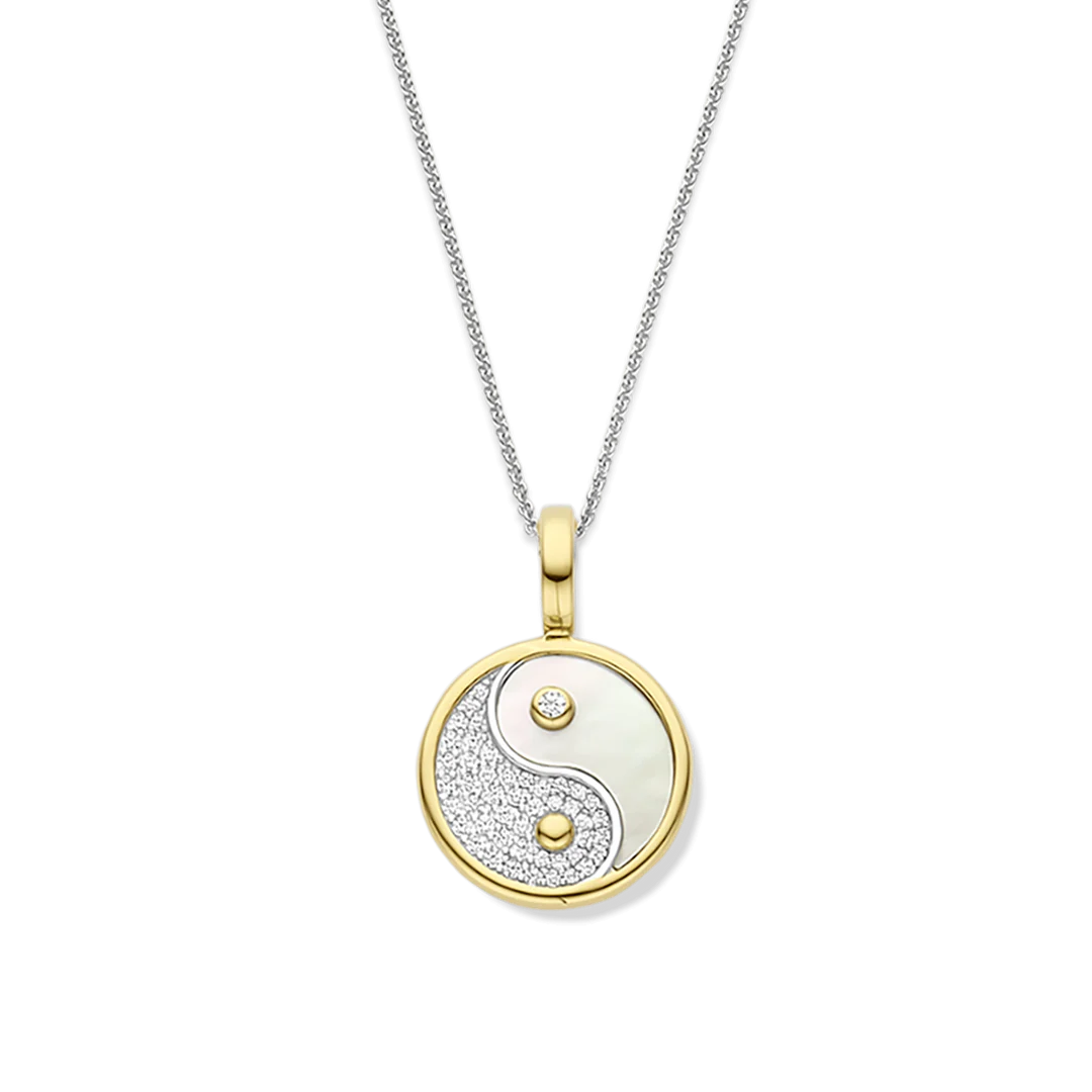 Vind je perfecte balans met de TI SENTO vergulde Yin Yang hanger 6843MW, een sieraad dat harmonie, dualiteit en moderne elegantie belichaamt. Gemaakt van hoogwaardig 925 sterling zilver, omhult deze hanger het tijdloze yin-yang symbool. De ene helft schittert met pavé gezette cubic zirconia, terwijl de andere helft glinstert met een parelmoeren inleg, wat een opvallend contrast van texturen en licht creëert. De hanger wordt geleverd met een sierlijke zilveren collier van 45 cm. Ontworpen voor moeiteloze veelzijdigheid, hangt deze hanger aan een vergulde clipring, waardoor je haar aan je favoriete kettingen kunt bevestigen en je look kunt personaliseren. Of je e hanger nu solo draagt als een betekenisvol statement of combineert met andere bedels, deze hanger brengt een vleugje spirituele elegantie en eigentijdse stijl in elke sieradencollectie. Nikkelvrij en hypoallergeen, het zorgt voor luxueus comfort bij elk draagmoment. Laat deze yin-yang hanger je dagelijkse herinnering zijn aan balans, energie en tijdloze verfijning.