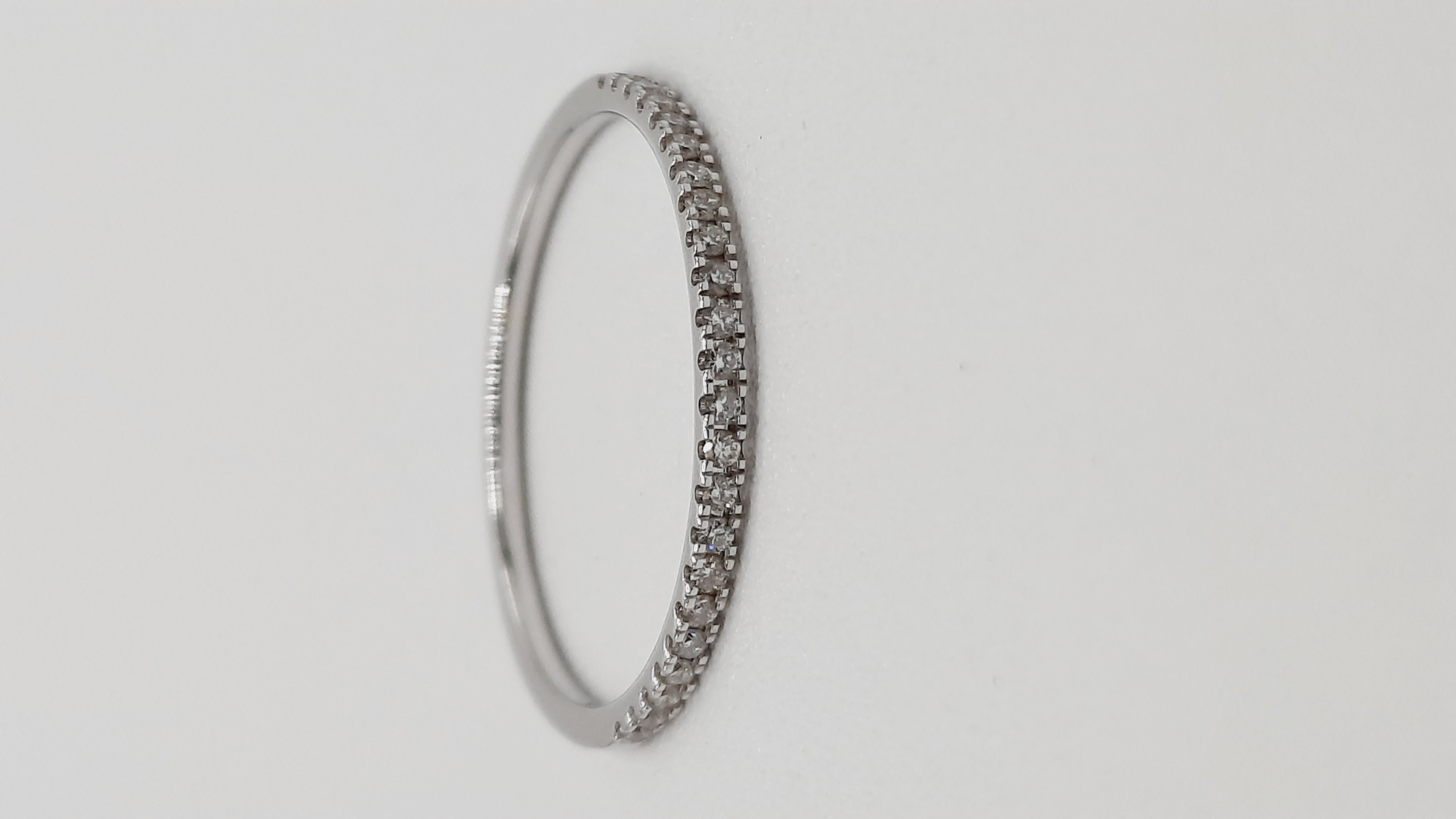 De witgouden ring met modelnummer 0002319 is een verfijnd sieraad dat is gemaakt van 14kt goud. De ring bevat 23 briljant geslepen diamanten met een totale gewicht van 0,12 karaat, in de zuiverheid SI1 en kleur H (Wesselton wit). Draag deze elegante ring bij formele gelegenheden voor een verfijnde uitstraling.