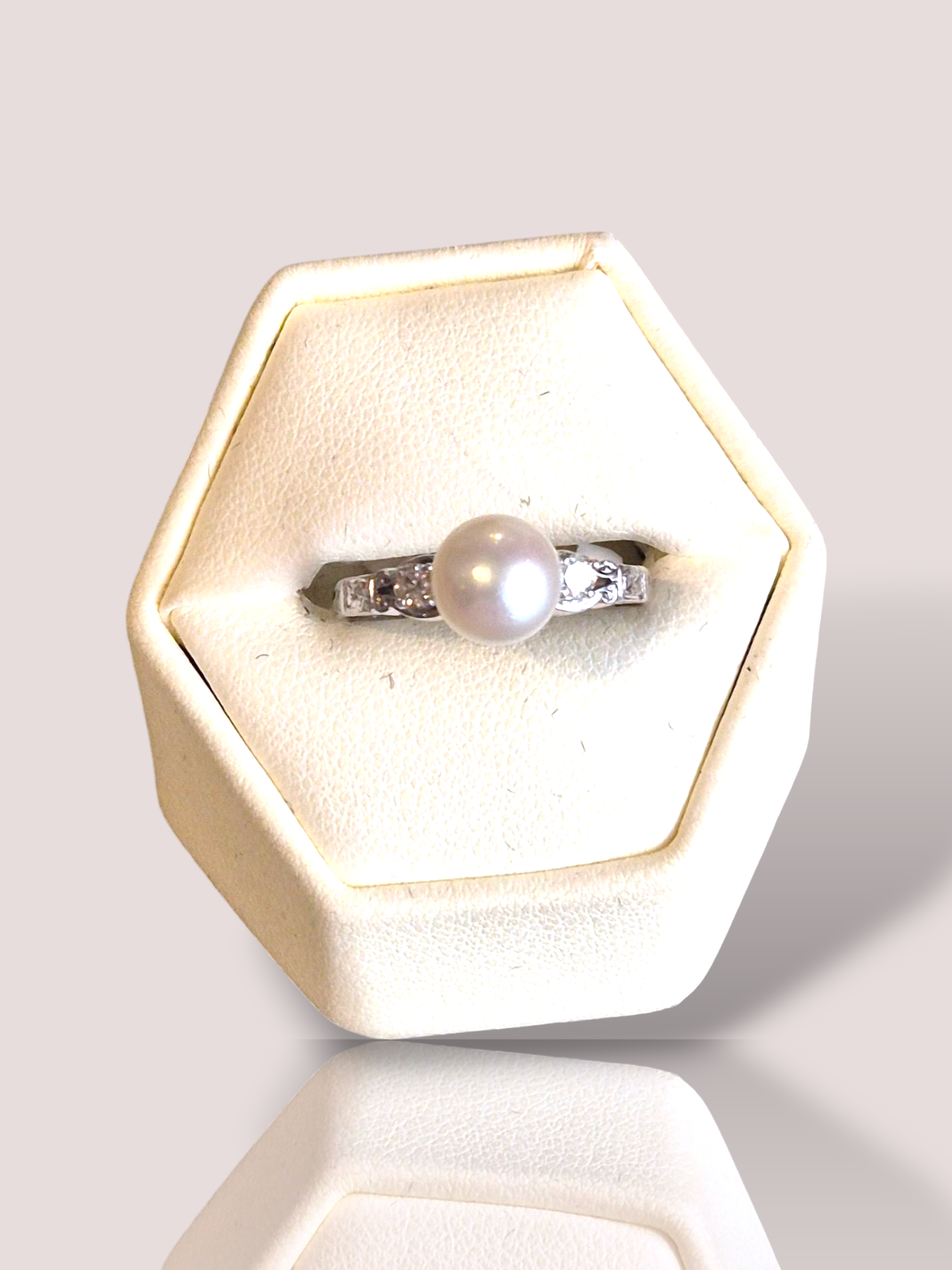 Deze prachtige vintage platina ring is bezet met een parel van 7,5 mm en 2 prachtige diamanten van in totaal 0,12ct, waardoor het een tijdloze en elegante uitstraling heeft. De ring is perfect voor speciale gelegenheden en kan zowel solo gedragen worden als gecombineerd met andere sieraden voor een luxe uitstraling. Draag deze ring met trots en laat je innerlijke schoonheid stralen.