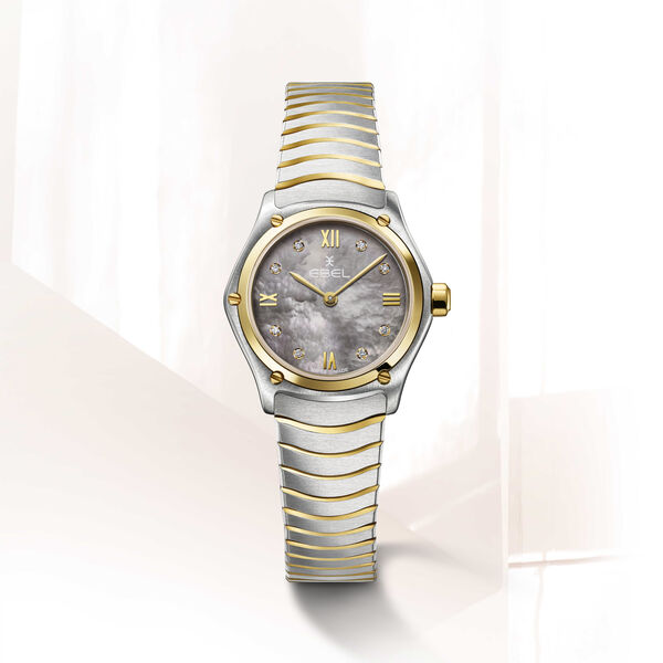 De Ebel Sport Classic 1216640 is een stijlvol horloge met een sportieve uitstraling. Het horloge heeft een grijze parelmoer wijzerplaat met goudkleurige wijzers en een diamanten (0.031ct.), en een roestvrijstalen band met 18krt gouden schakels. Het horloge is waterdicht tot 50 meter en heeft een quartz uurwerk. Draag dit horloge als een statement piece bij zowel casual als formele gelegenheden. Dit horloge geeft elke outfit een luxe uitstraling.