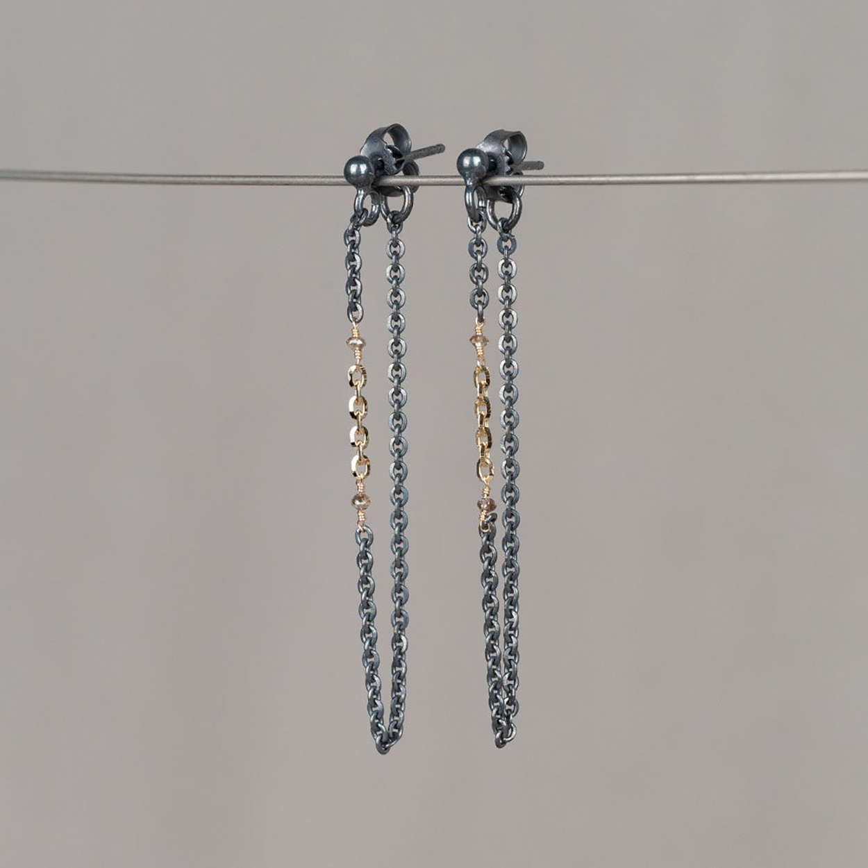 Oorbellen gemaakt van geoxideerd zilver met 14 karaat goud en 2 bruine diamanten. Combineer met het bijpassende collier en de bijpassende armband voor een complete look!