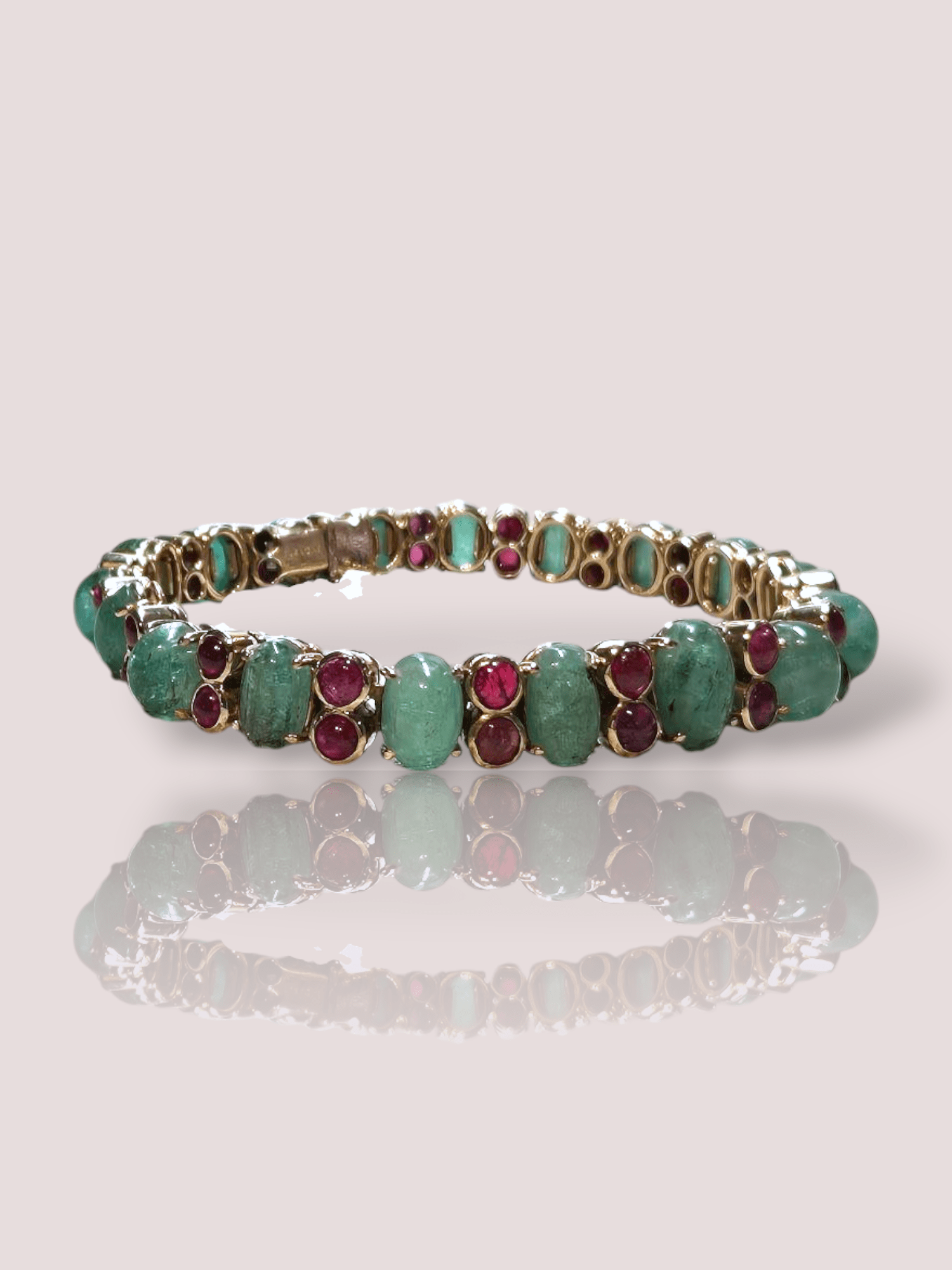 Deze vintage 18k geel gouden armband is prachtig versierd met 36 cabochon geslepen robijnen en 18 jadeiet stenen, waardoor het een unieke en luxe uitstraling heeft. De armband is perfect om te dragen bij speciale gelegenheden of om je dagelijkse outfit op te fleuren. Combineer het met andere gouden sieraden voor een complete look. Een echte eyecatcher voor jouw collectie!

Deze armband is 18cm lang en weegt 29,76 gram.
