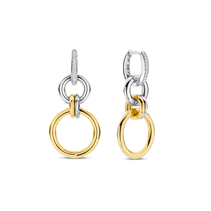 Deze TI SENTO oorbellen 78018ZY zijn een gedurfde interpretatie van moderne elegantie, waarbij strakke geometrie wordt gecombineerd met tijdloze verfijning. Gemaakt van hoogwaardig 925 sterling zilver, hebben deze oorbellen een reeks van in elkaar grijpende cirkels, waarbij gepolijste goudkleurige schakels worden gecombineerd met glanzende zilverkleurige elementen. Een pavégezette cubic zirconia hoepel verankert het ontwerp en voegt een verfijnde schittering toe die het licht vangt bij elke beweging. Het dynamische samenspel van texturen en tinten maakt deze oorbellen veelzijdig. Nikkelvrij en hypoallergeen, zorgen ze voor luxueus comfort bij elk draagmoment. Laat deze in elkaar grijpende hoepels jouw statement zijn van kracht, vloeiendheid en eindeloze stijlmogelijkheden.