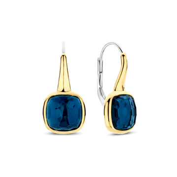De TI SENTO oorbellen 7989DB zijn het toonbeeld van moeiteloze allure. Gemaakt van hoogwaardig 925 sterling zilver, hebben deze oorhangers een betoverende gefacetteerde diepblauwe steen, gezet in een stralend goudkleurige omlijsting die de rijke, oceaanachtige tint versterkt. Deze oorbellen bieden zowel een veilige draagervaring als sierlijke beweging, waarbij ze het licht vangen bij elke draai. De diepblauwe tint roept het mysterie van middernachtelijke wateren op, waardoor deze oorbellen een opvallende maar veelzijdige toevoeging zijn aan elke sieradencollectie. Nikkelvrij en hypoallergeen, zorgen ze voor luxueus comfort bij elk draagmoment. Of je nu strand elegantie of stedelijke chic uitstraalt, deze statement oorbellen brengen een vleugje verfijnde elegantie aan je look.