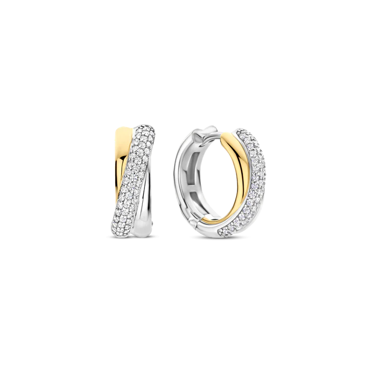 Deze TI SENTO oorbellen 78012ZY combineren textuur en schittering. Gemaakt van 925 sterling zilver, hebben ze een elegant verweven ontwerp met een vergulde band en een platinakleurige streng met pavé gezette cubic zirconia. Dit contrast zorgt voor een tijdloze en eigentijdse look. Deze oorbellen voegen een vleug glamour toe aan zowel casual als elegante outfits. De veilige scharnier sluiting zorgt voor comfort, waardoor ze de hele dag gedragen kunnen worden. Nikkelvrij en hypoallergeen voor luxueus comfort. Of je nu geniet van zomermomenten of avondelijke elegantie, deze oorbellen brengen stralende charme aan je sieradencollectie.