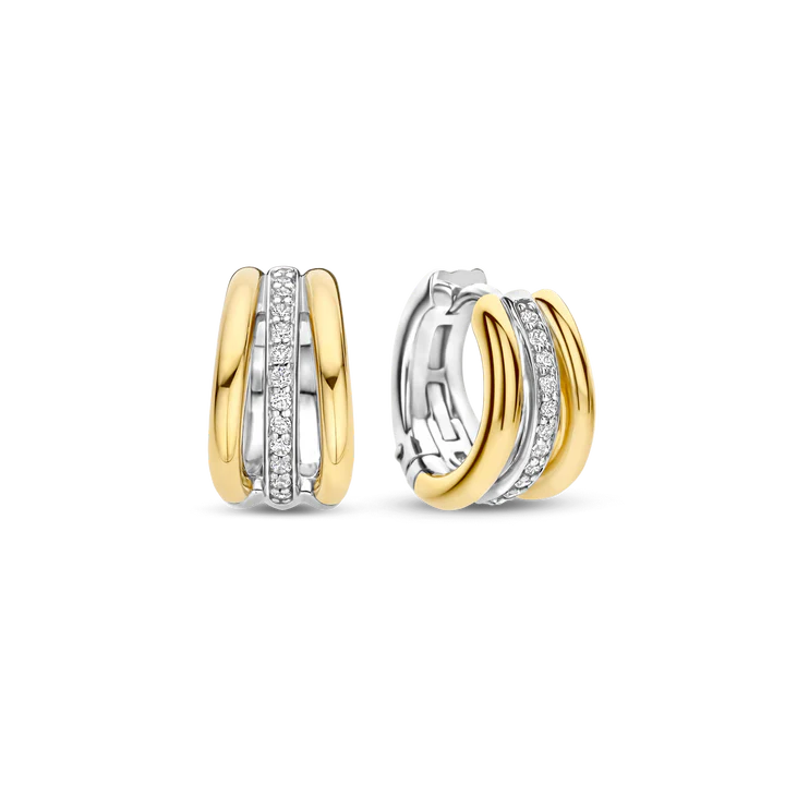 Deze TI SENTO oorbellen 78010ZY combineren diepte, contrast en schittering. Gemaakt van 925 sterling zilver, hebben ze een driedubbel hoepelontwerp: twee goudkleurige banden omarmen een platinakleurige hoepel met pav&eacute; gezette cubic zirconia. Deze oorbellen voegen een elegante touch toe aan elke outfit. De veilige scharnier sluiting zorgt voor comfort, waardoor ze de hele dag gedragen kunnen worden. Nikkelvrij en hypoallergeen voor luxueus comfort. Een mix van gouden warmte, ijzige schittering en eigentijds design, perfect voor elke gelegenheid.